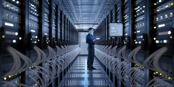 Centre de données moderne avec des serveurs et un technicien.