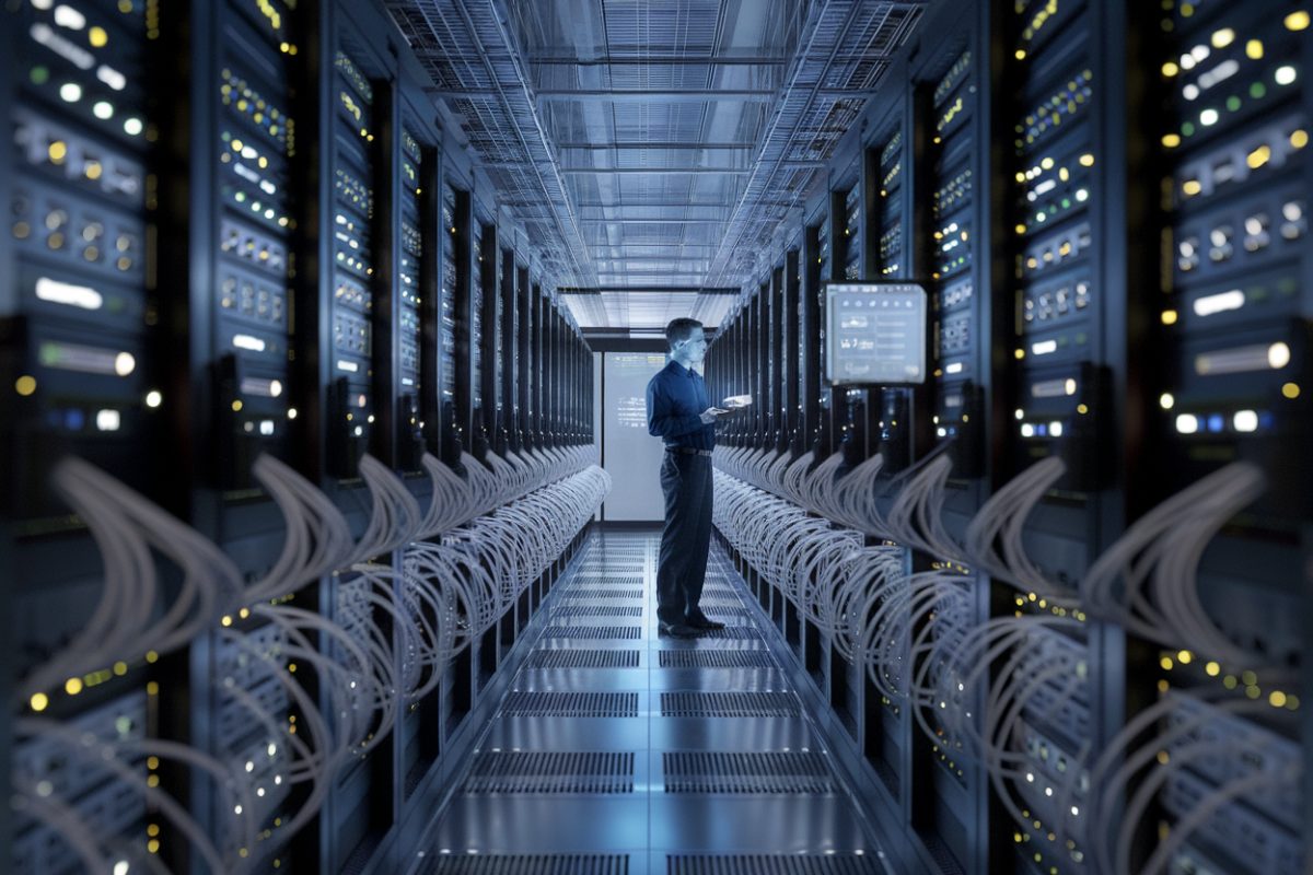 Centre de données moderne avec des serveurs et un technicien.